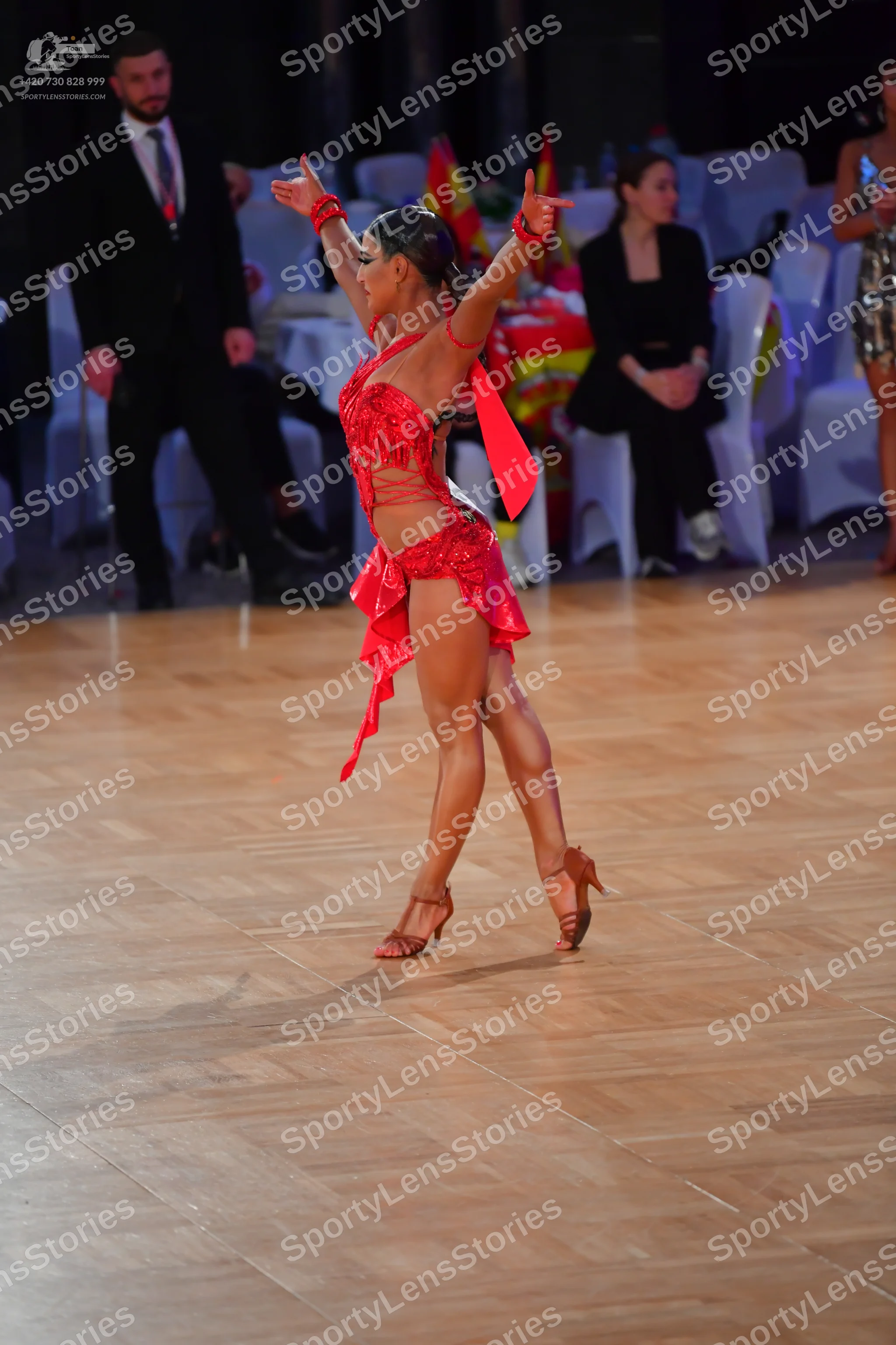 Dancesport competitor: Female dancer: red Latin dance dress with straps and flowing, textured fabric
