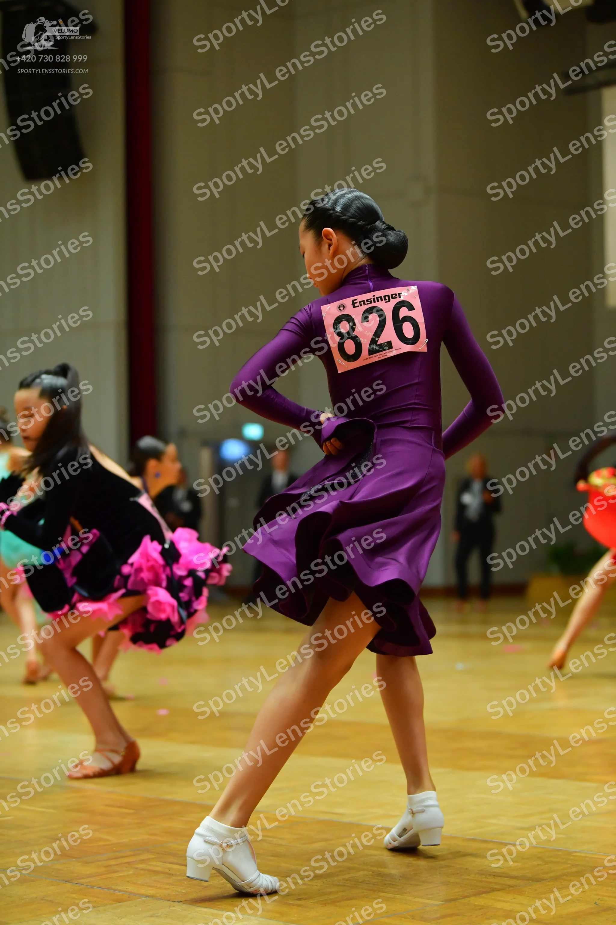 Dancesport competitor #826: Primary dancer: deep purple long-sleeved Latin dress with a flared skirt and whi