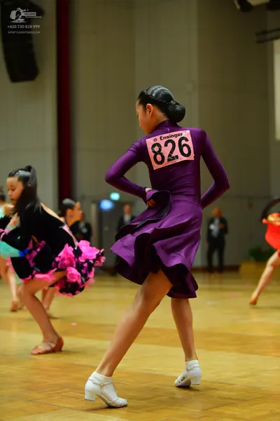Dancesport competitor #826: Primary dancer: deep purple long-sleeved Latin dress with a flared skirt and whi