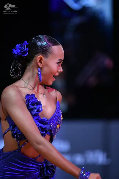 Dancesport competitor: Female dancer: deep blue latin dress with 3D floral embellishments, sequins, and
