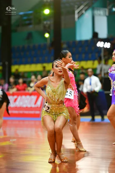 Dancesport competitor: ** Gold Latin dress
*   **Color:** Primarily gold with shimmering sequins