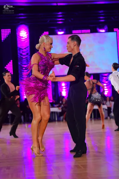 Dancesport competitor: Main female dancer: purple latin dress with sequins and long fringe, and a match