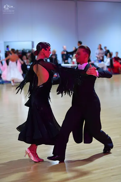Dancesport competitor: Female dancer: black latin dress with long sleeves and fringe