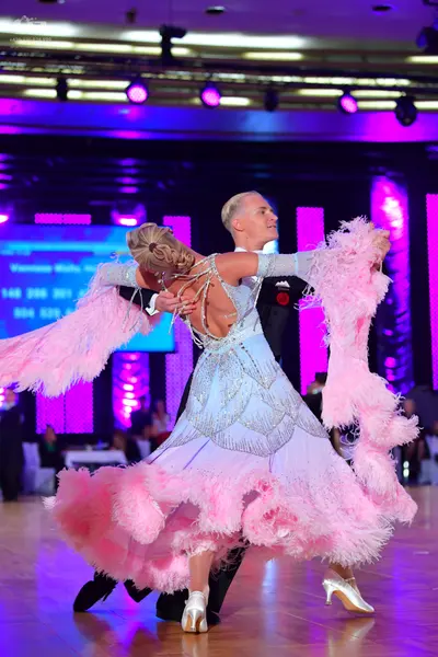 Dancesport competitor: Male dancer: black suit with a red boutonniere on the lapel
