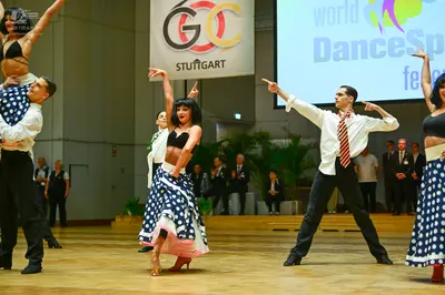 Dancesport competitor: Male dancer (left): white long-sleeved shirt, navy blue waistcoat with white pol
