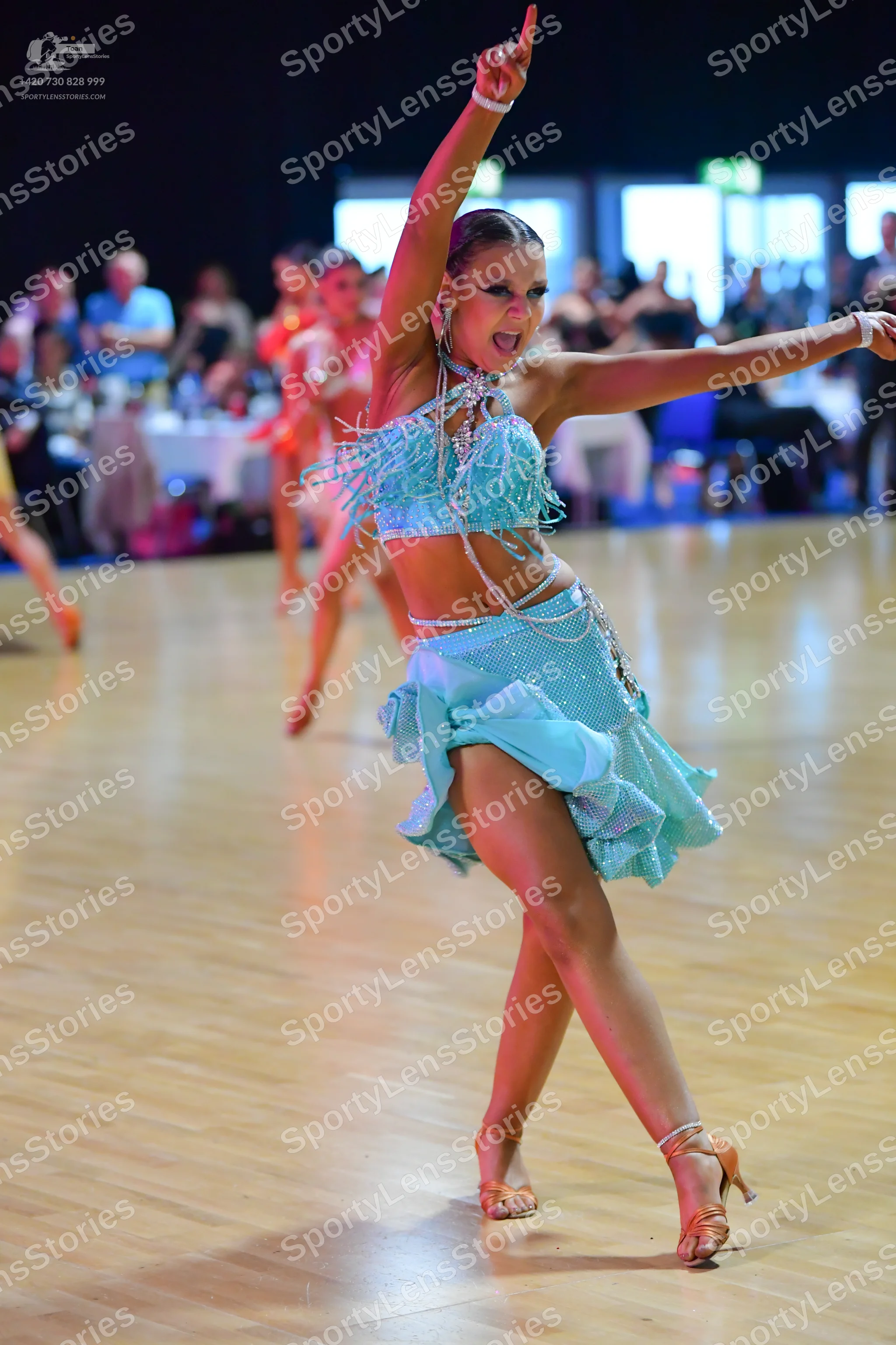 Dancesport competitor: Main female dancer: light blue two-piece Latin costume with a sequined/fringed c