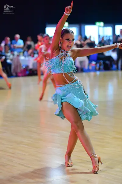 Dancesport competitor: Main female dancer: light blue two-piece Latin costume with a sequined/fringed c