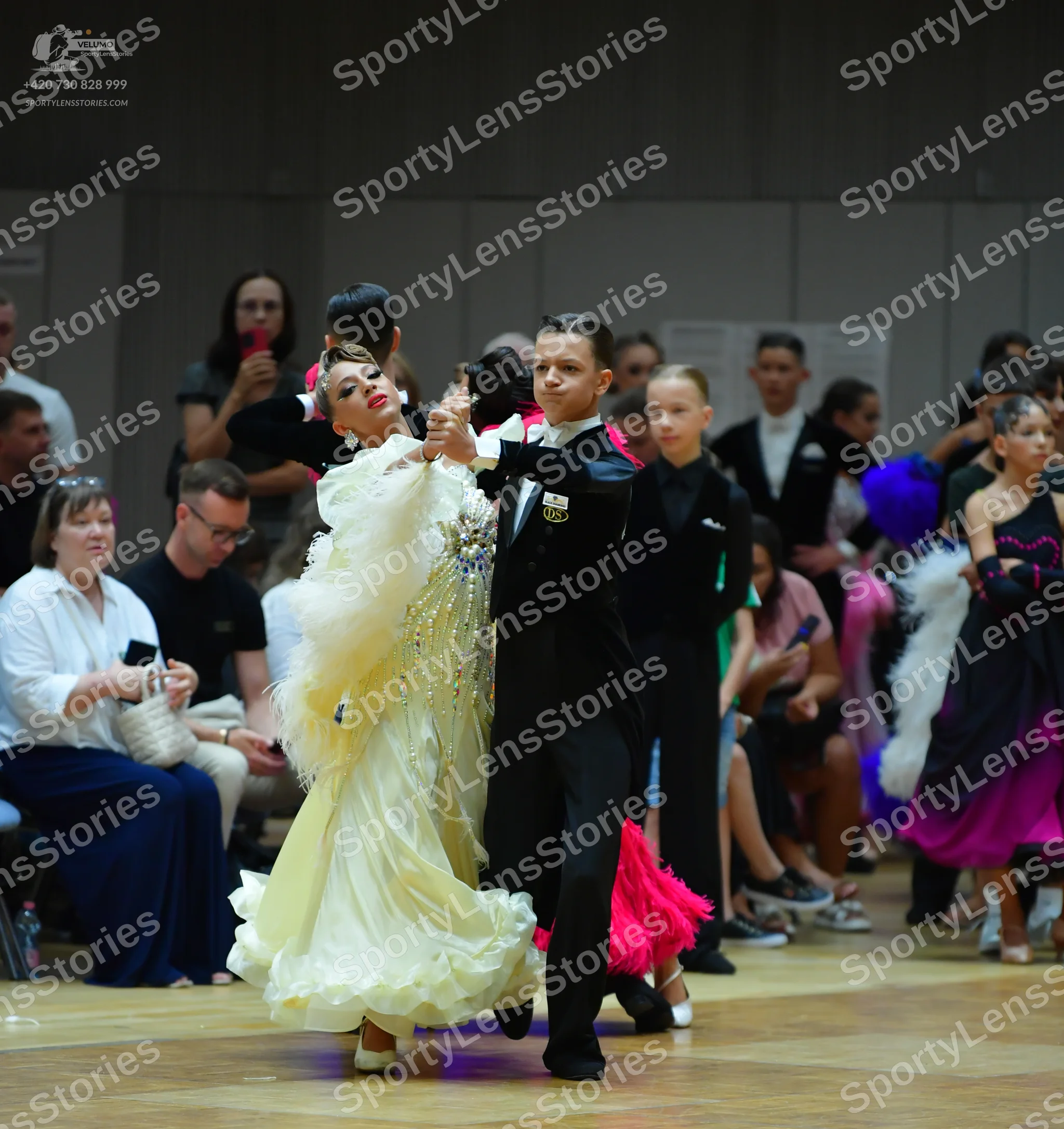 Dancesport competitor: Main female dancer: large, voluminous cream-colored ballgown with many layers of