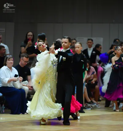 Dancesport competitor: Main female dancer: large, voluminous cream-colored ballgown with many layers of