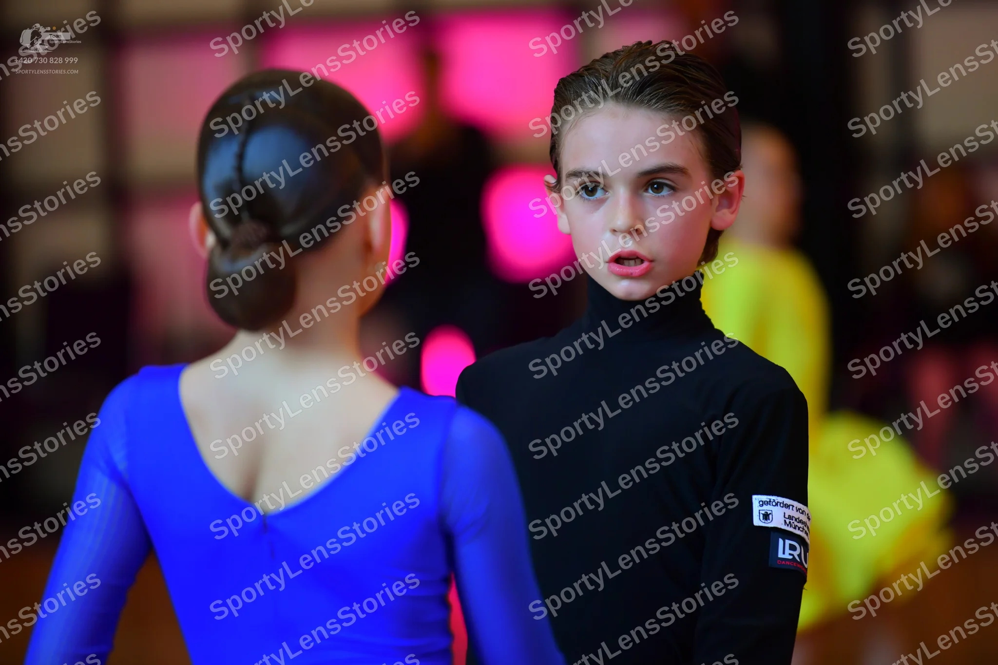 Dancesport competitor: Female dancer: bright blue long-sleeved dress with a V-neck