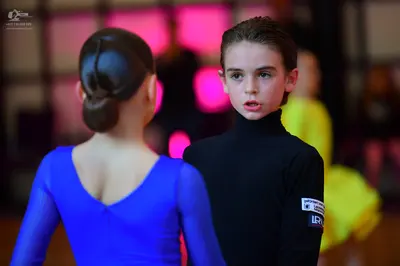 Dancesport competitor: Female dancer: bright blue long-sleeved dress with a V-neck