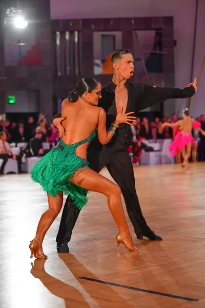 Dancesport competitor: Female dancer: green Latin dance dress with fringe