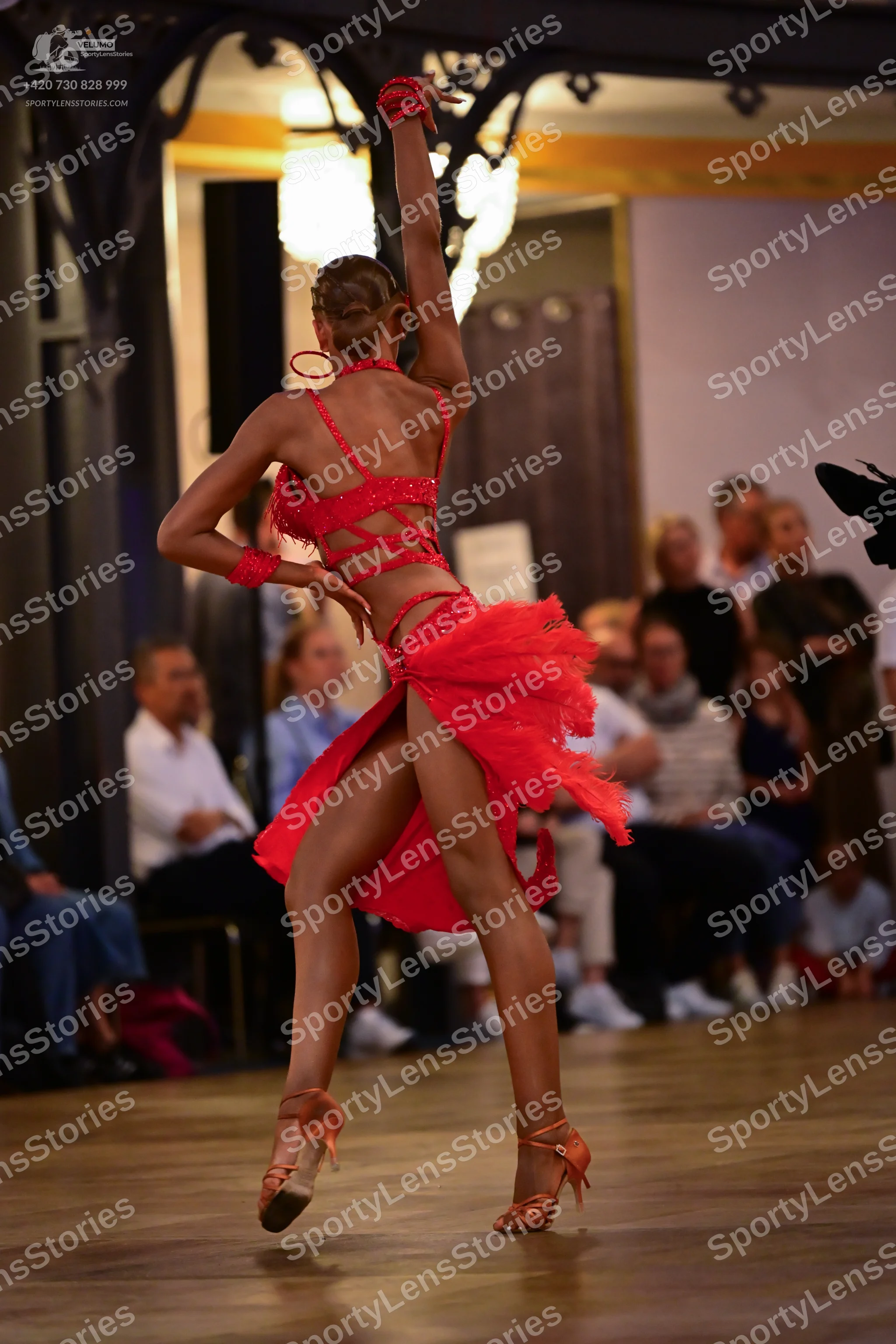 Dancesport competitor: Female dancer: red latin dress with a strappy back and red wristbands