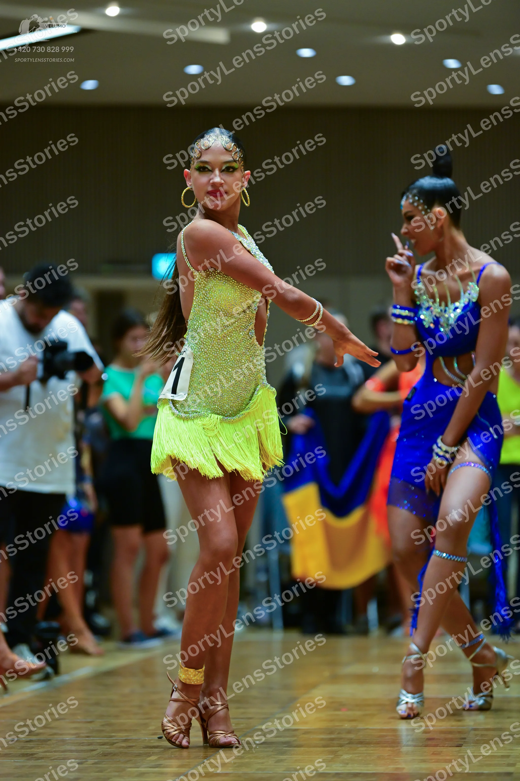 Dancesport competitor: Female dancer 1: lime green sequined latin dress with fringe skirt, gold hoop ea