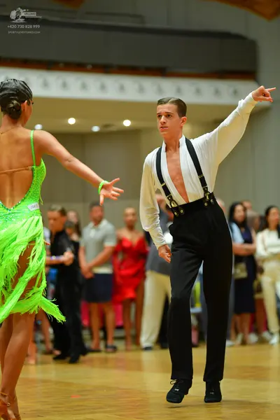 Dancesport competitor: Female dancer: lime green Latin dance dress with sequins and long fringe
