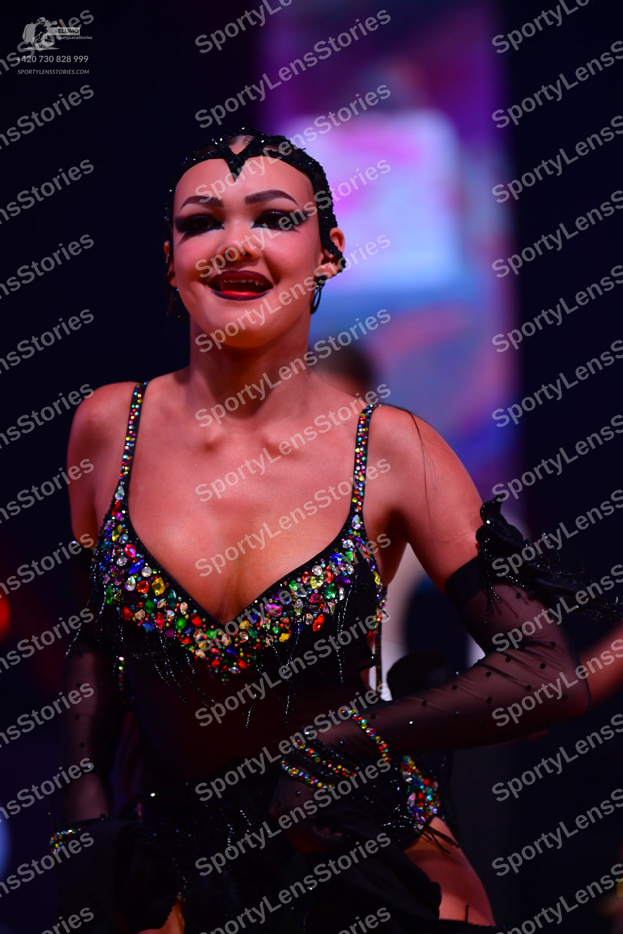 Dancesport competitor: Female dancer: black latin dress with multi-colored rhinestones and fringe, pair