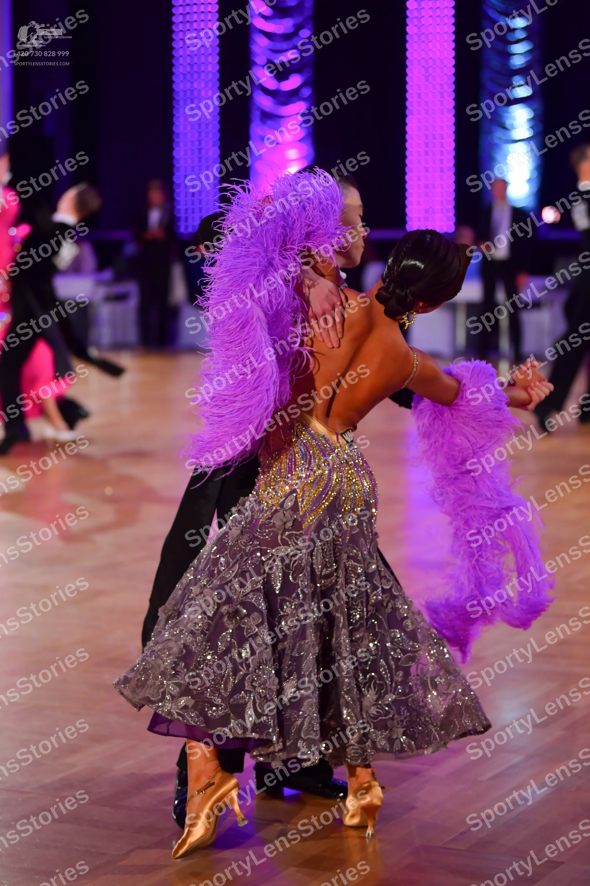 Dancesport competitor: Main female dancer: backless ballroom dress with a voluminous silver and grey pa