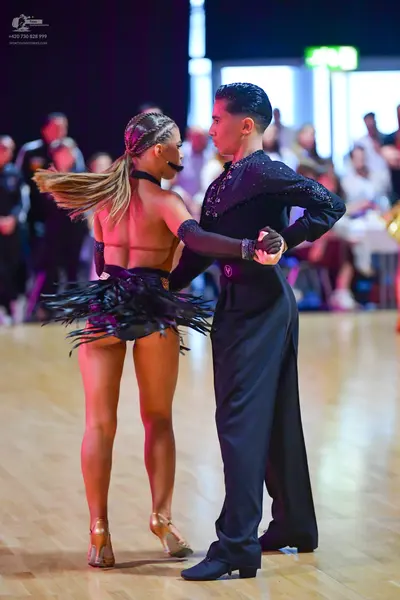 Dancesport competitor: Male dancer: black long-sleeved shirt with subtle embellishments and black trous