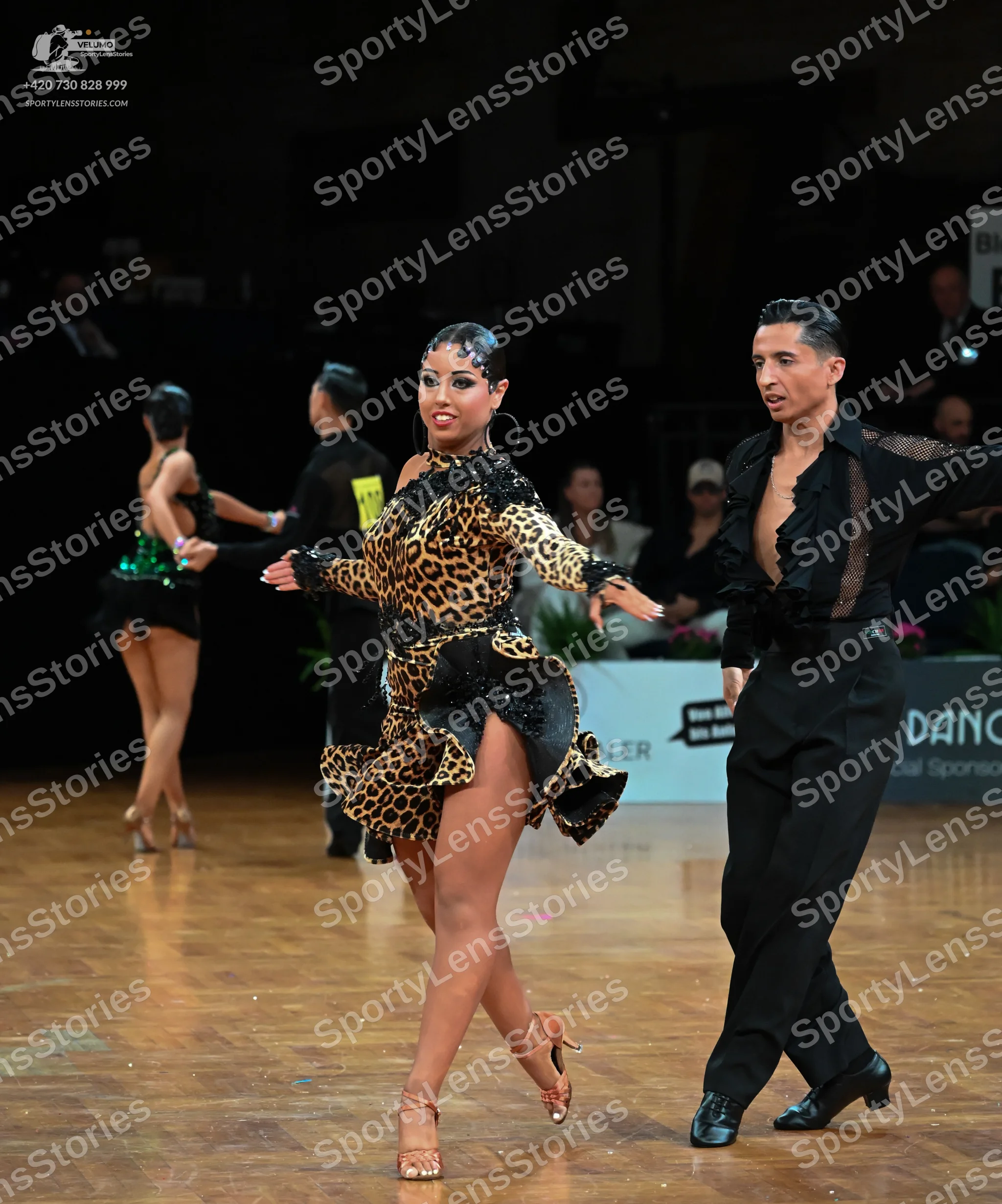 Dancesport competitor: Female dancer (foreground): leopard print Latin dress