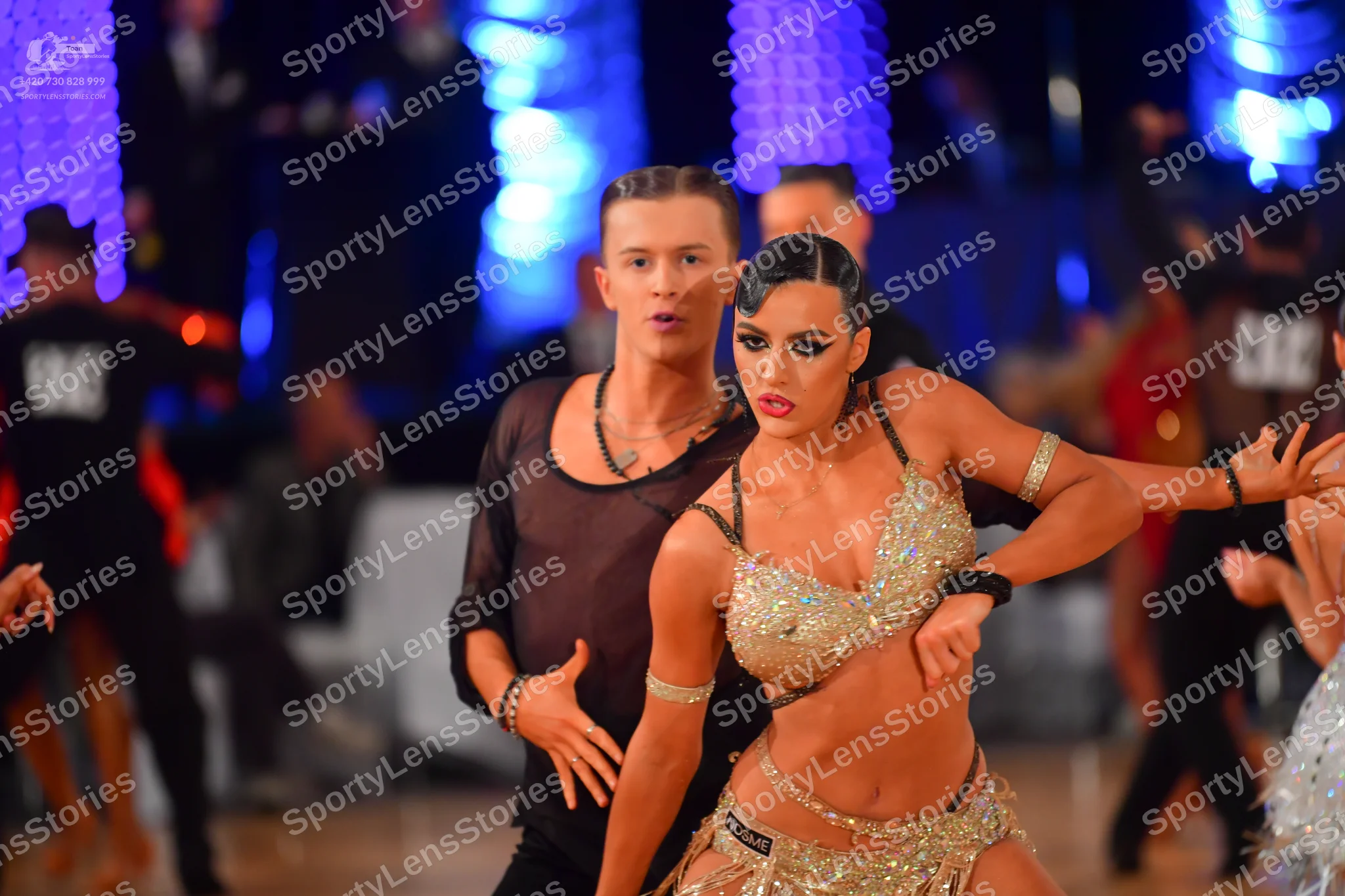 Dancesport competitor: Male dancer: dark brown or black long-sleeved shirt with sheer fabric on the sle