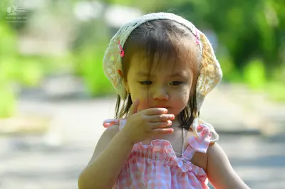 Dancesport competitor: Child: pink and white checkered sleeveless top and a white lace bonnet