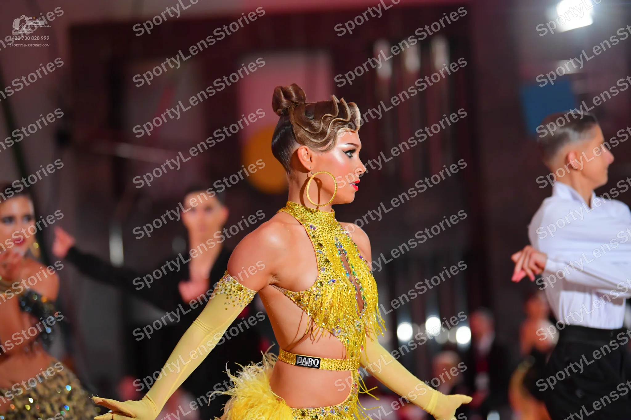Dancesport competitor #5498: Main female dancer: yellow latin dress with sequins and fringe, featuring a cuto