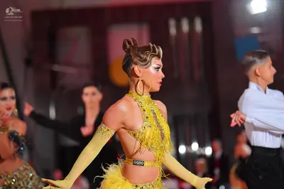 Dancesport competitor #5498: Main female dancer: yellow latin dress with sequins and fringe, featuring a cuto