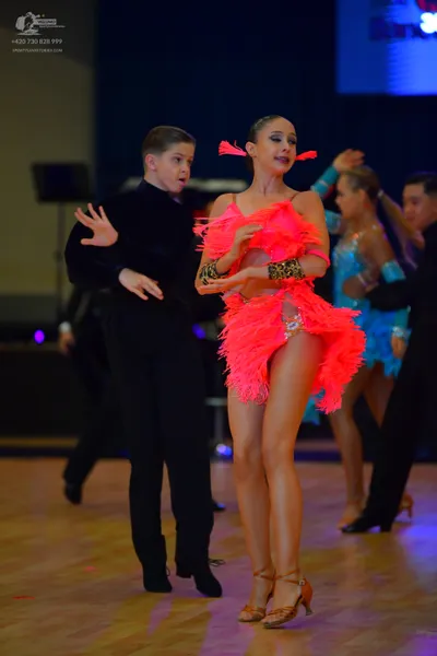 Dancesport competitor: Male dancer (foreground): black long-sleeved top and black trousers
