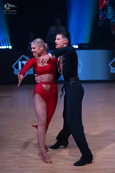 Dancesport competitor: Female dancer: red sequined latin dress with cut-outs and a high slit