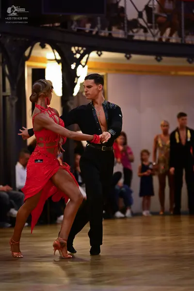 Dancesport competitor: Female dancer: red latin dress with sequins and cutouts