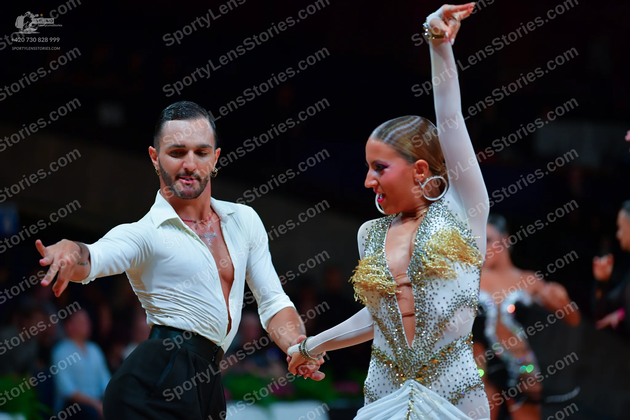 Dancesport competitor: Male dancer: white long-sleeved shirt unbuttoned at the chest and black trousers