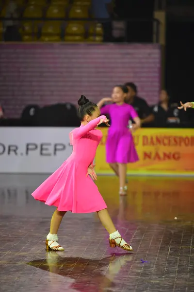 Dancesport competitor: Female dancer 1: bright pink long-sleeved dress with a flared skirt and smooth f