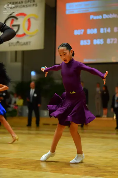 Dancesport competitor: Female dancer: purple long-sleeved Latin dress with a flared skirt