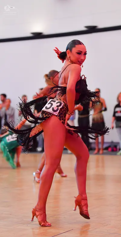 Dancesport competitor #53: Female dancer: black Latin dress with long black fringe and a gold/tan patterned