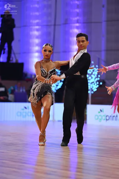 Dancesport competitor: Female dancer: dark grey/black sequined latin dress with thin straps and fringe/