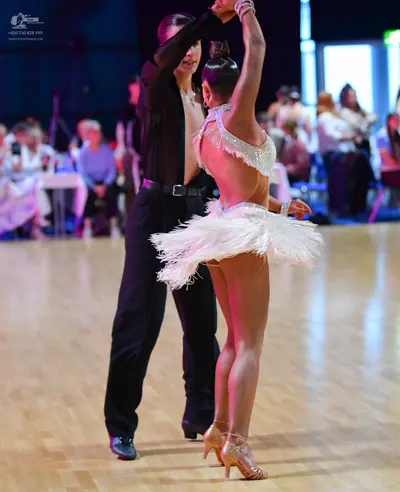 Dancesport competitor: Male dancer: black long-sleeved shirt, black trousers, black belt with silver bu