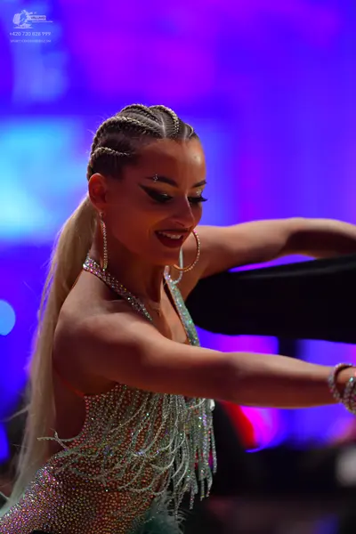 Dancesport competitor: Female dancer: light silvery/nude latin dress with rhinestones/sequins and long 