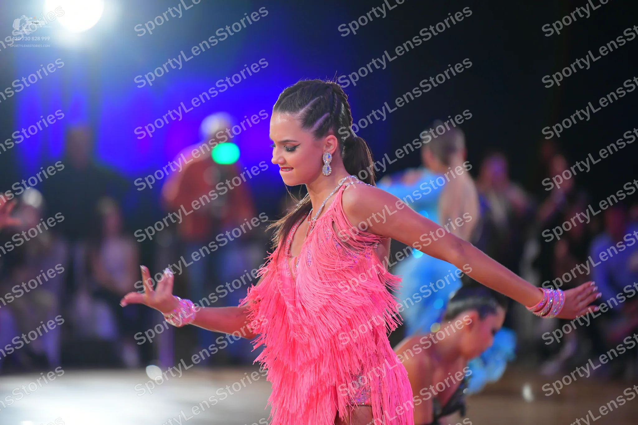 Dancesport competitor: Female dancer in foreground: pink latin dress with fringe and sequin details, sp