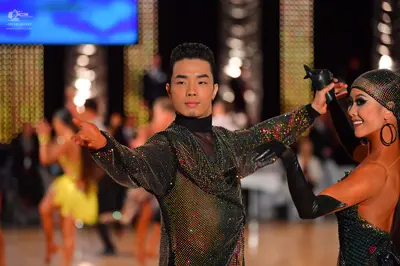 Dancesport competitor: Male dancer: dark long-sleeved top with multicolored sequins