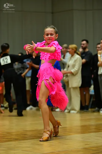 Dancesport competitor #52: Female dancer (center): bright pink Latin dress with ruffles and fringe