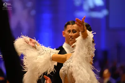 Dancesport competitor: Female dancer: white/off-white Latin dress decorated with sequins, crystals, and