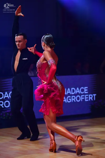 Dancesport competitor: Male dancer: black long-sleeved shirt with a white pocket square and black trous