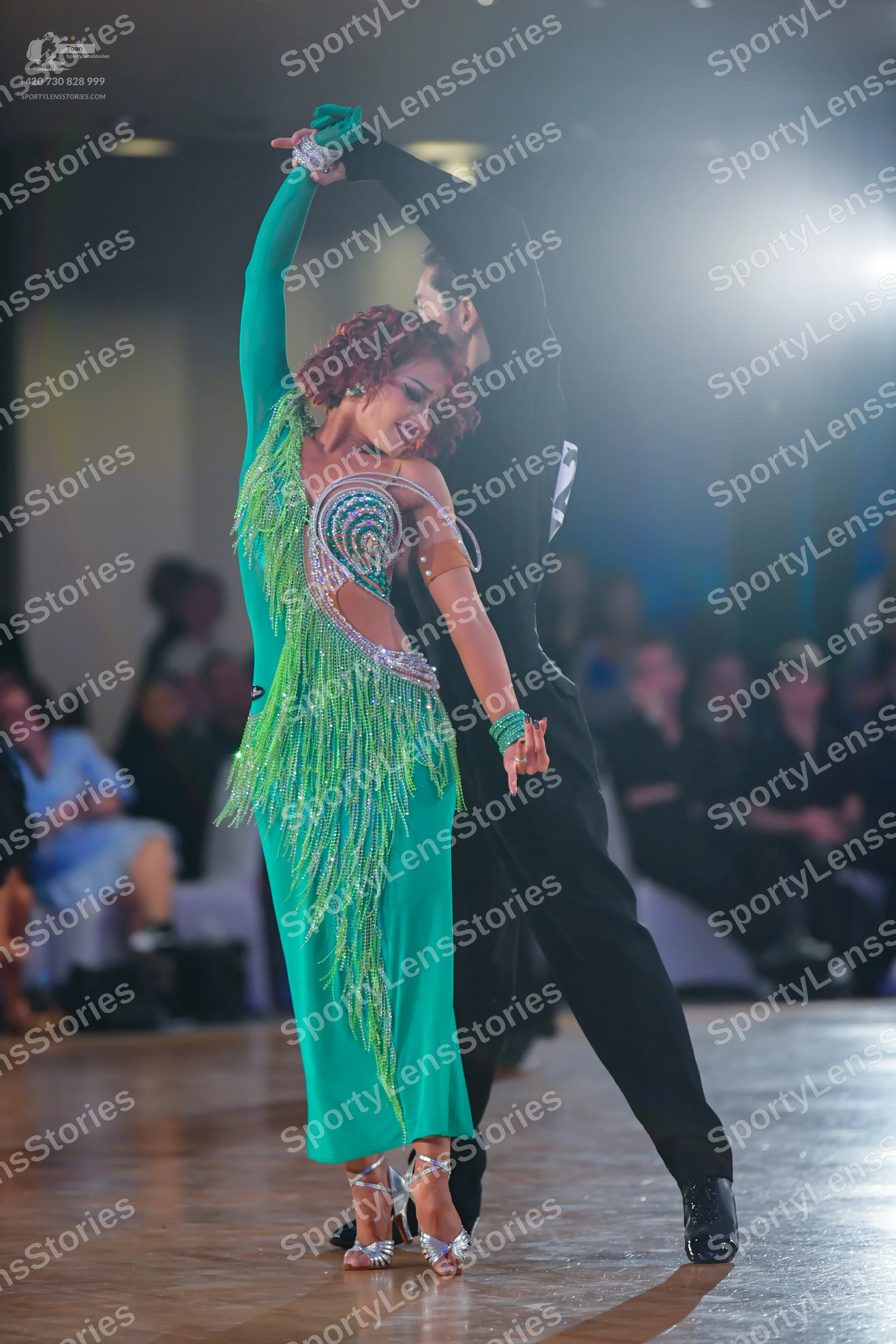 Dancesport competitor: Female dancer: emerald green long-sleeved Latin dress with sequin embellishments