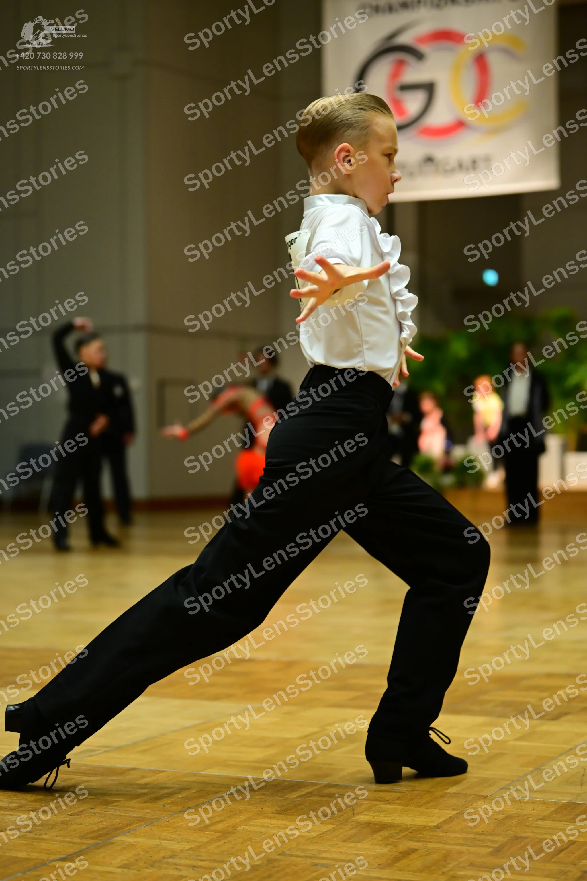 Dancesport competitor: Main male dancer: white long-sleeved shirt with ruffled cuffs and black trousers