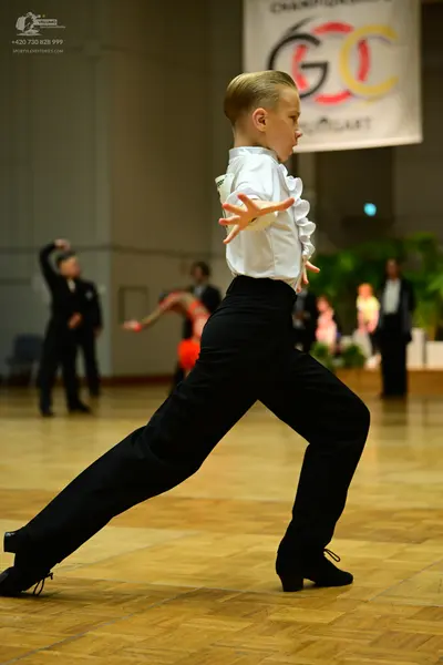 Dancesport competitor: Main male dancer: white long-sleeved shirt with ruffled cuffs and black trousers