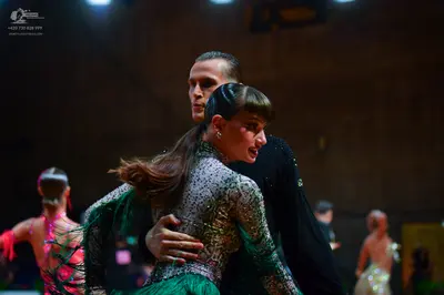 Dancesport competitor: Main female dancer: silver/grey sequined long-sleeved bodice with a bright green