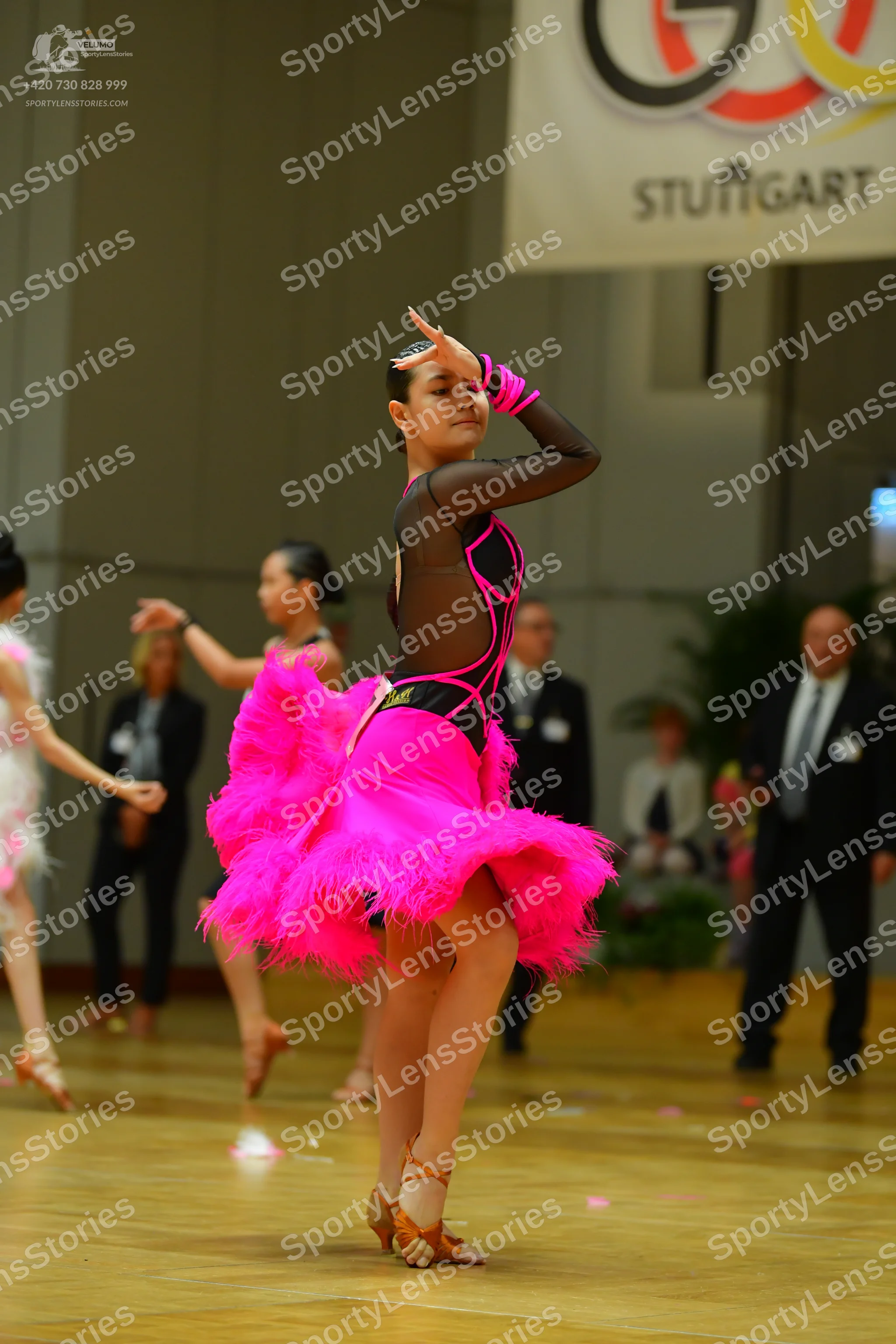 Dancesport competitor: Main dancer: pink and black Latin dress with a voluminous pink feathered skirt a