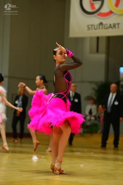 Dancesport competitor: Main dancer: pink and black Latin dress with a voluminous pink feathered skirt a