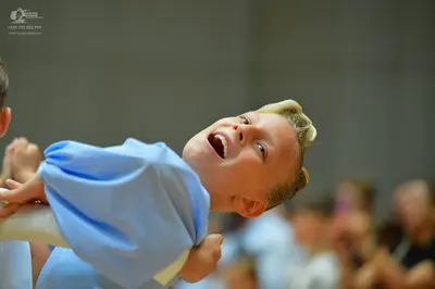 Dancesport competitor: Male dancer: light blue costume made of smooth fabric, possibly satin