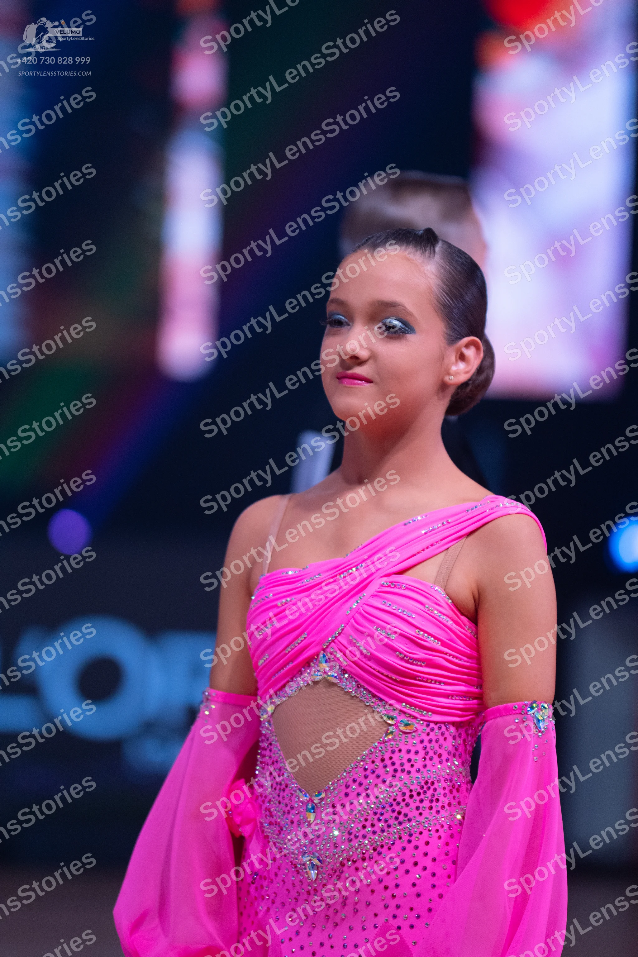 Dancesport competitor: Female dancer: bright pink latin dance dress with one-shoulder design, sequin an